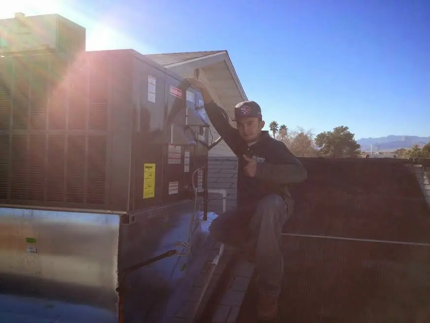 HVAC technician performing Air Duct Repair on a rooftop unit in Orange City